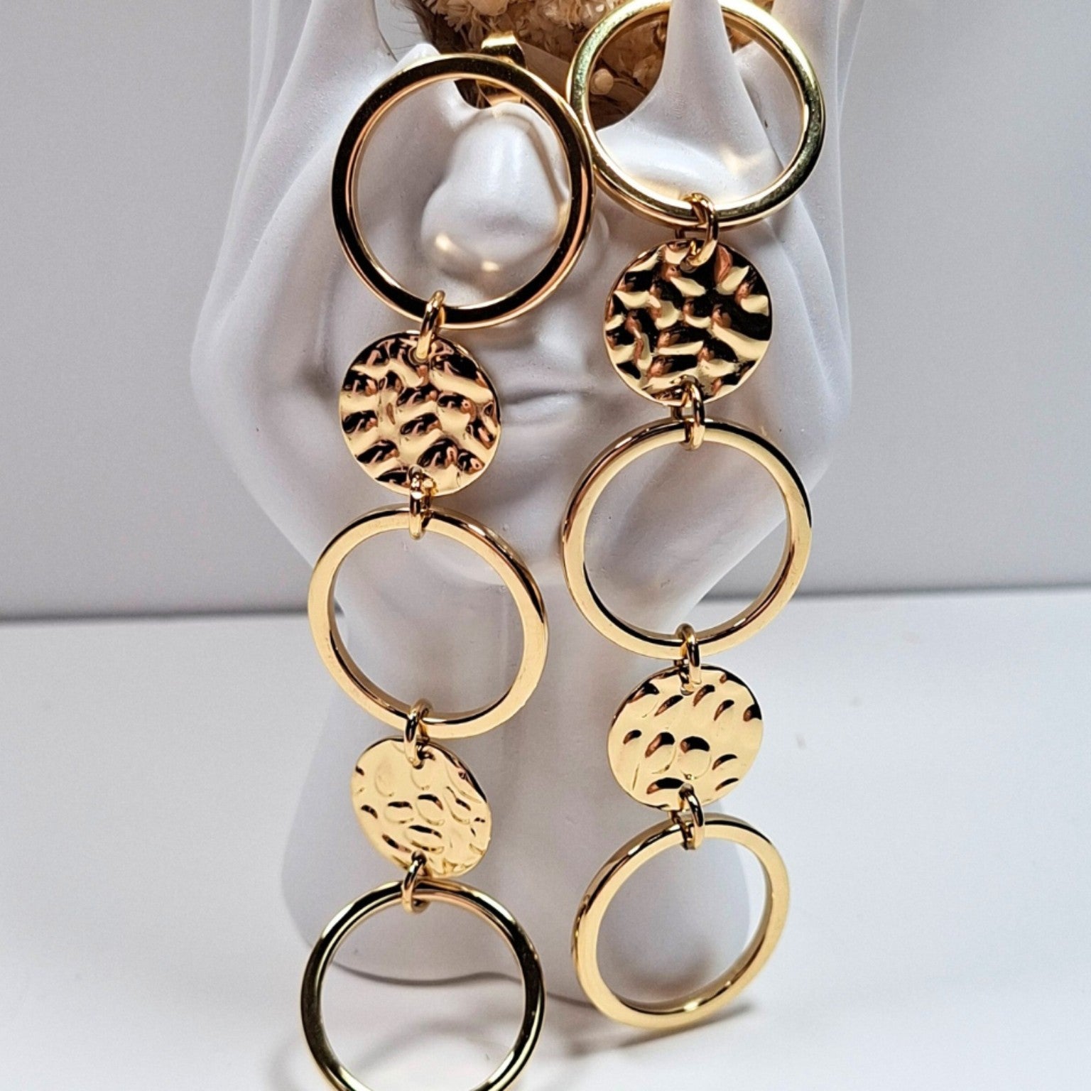 Boucle d’oreille dorée à cercles martelés portée sur oreille femme