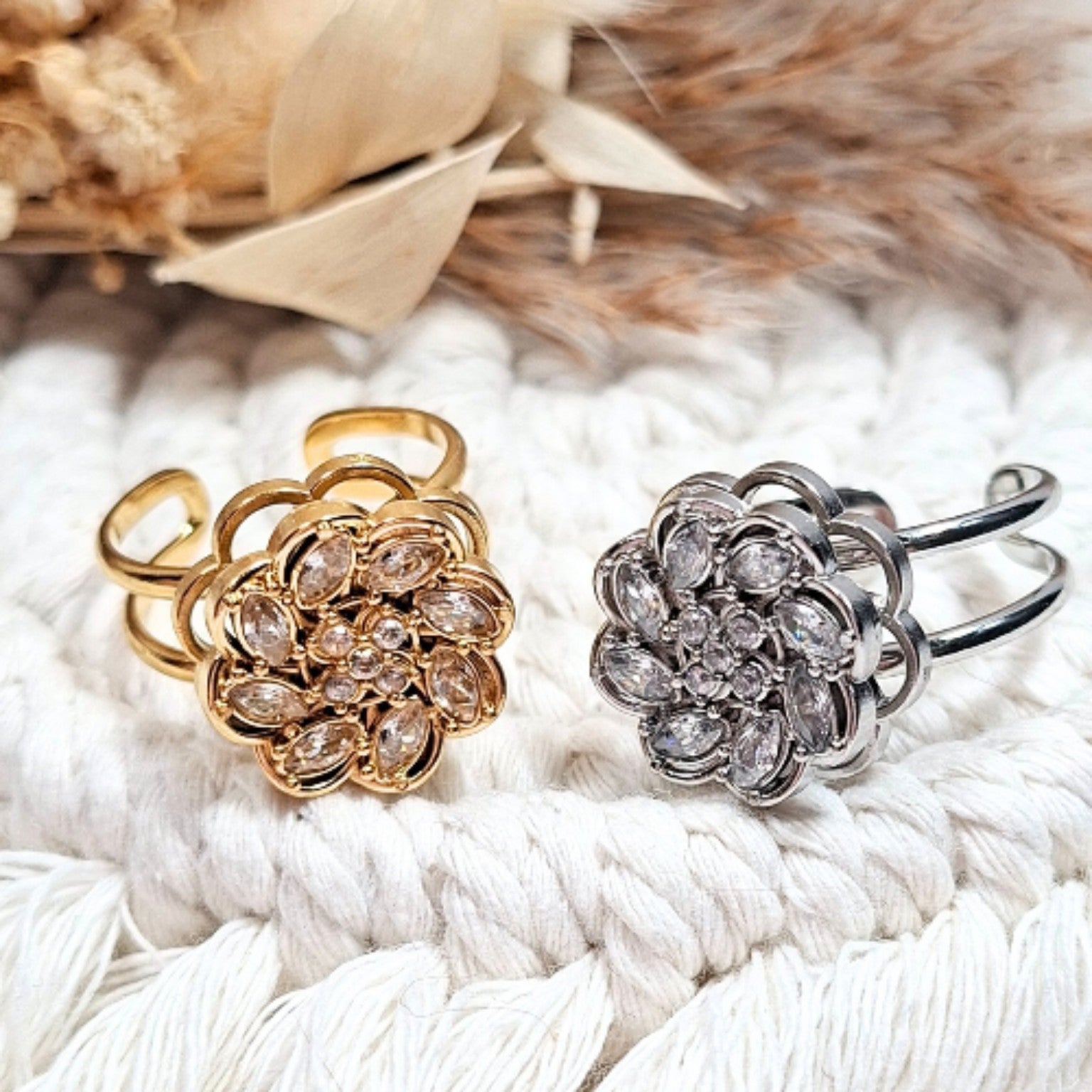 bague fleur dorée et bague fleur argentée en acier inoxydable sur fond naturel
