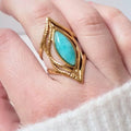 Bague dorée ajustable en acier inoxydable avec pierre turquoise marquise, portée au doigt d’une femme
