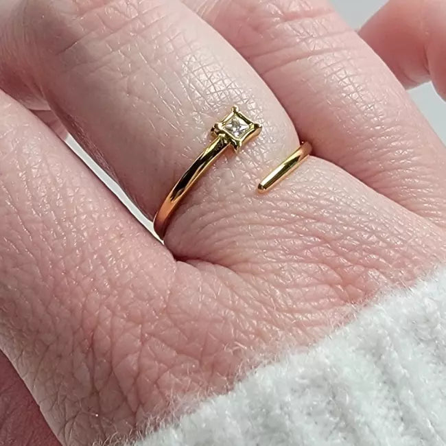Bague ajustable dorée en acier inoxydable avec zircon carré, portée au doigt d’une femme