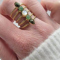 Bague dorée femme multi-rangs en acier inoxydable ajustable, décorée de cabochons verts et blanc nacré — vue portée au doigt.