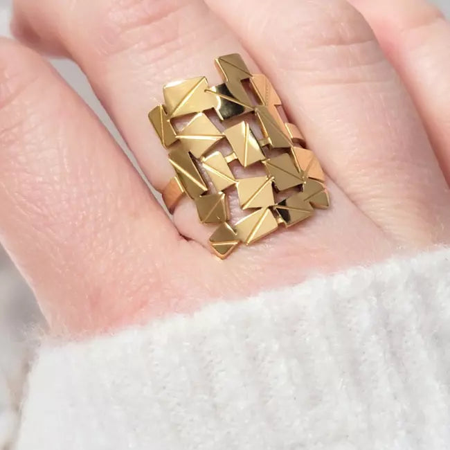 Bague ajustable dorée en acier inoxydable, design graphique géométrique, portée au doigt d’une femme
