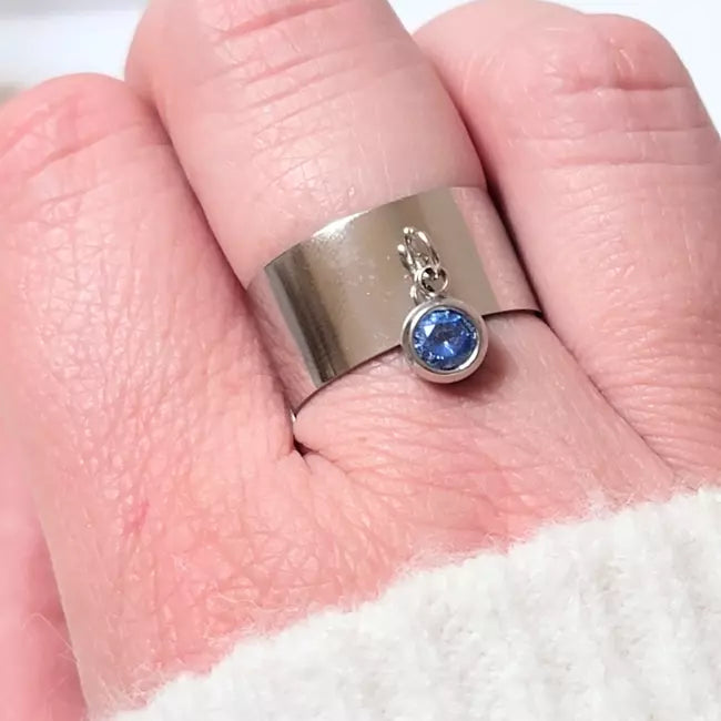 Bague personnalisée en acier inoxydable argenté avec pierre de naissance bleue, portée au doigt