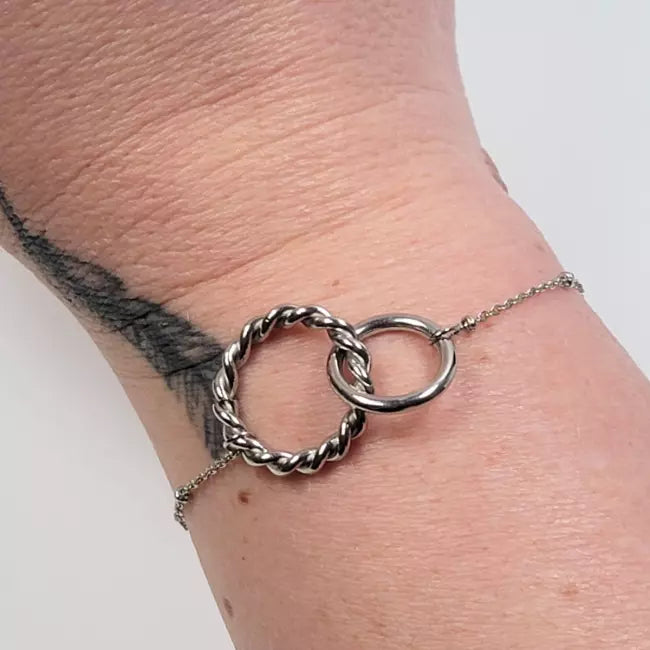 Bracelet argenté femme avec deux anneaux entrelacés en acier inoxydable