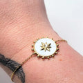 Bracelet doré femme avec médaillon rond étoile et fond nacré