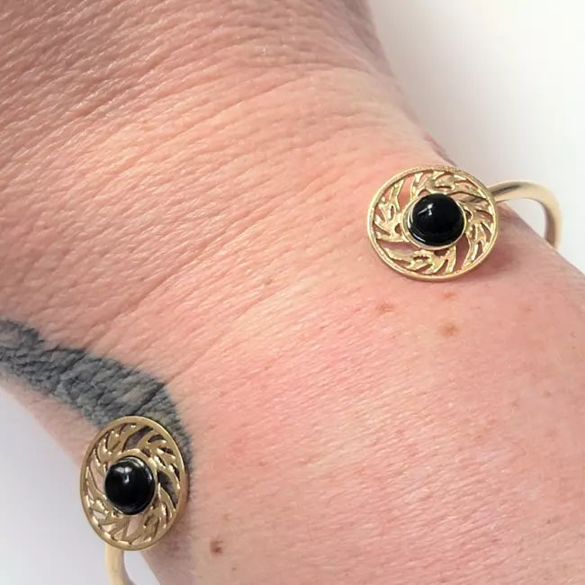 Bracelet jonc doré femme avec deux cabochons noirs et motifs ajourés