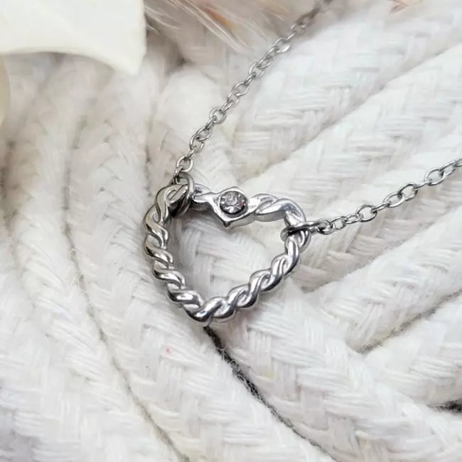 Collier cœur torsadé argenté en acier inoxydable, pendentif ajouré décoré d’un petit strass.