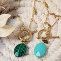 Colliers dorés en acier inoxydable avec pendentifs verts et bleus effet pierre, chaîne pampilles et fermoir toggle.