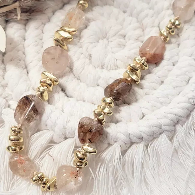 Collier doré bohème en acier inoxydable, pierres naturelles brun-rosé et perles dorées, présenté à plat.