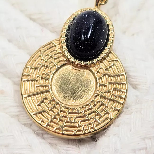 Détail du pendentif médaillon doré texturé avec cabochon bleu nuit pailleté en ovale – zoom