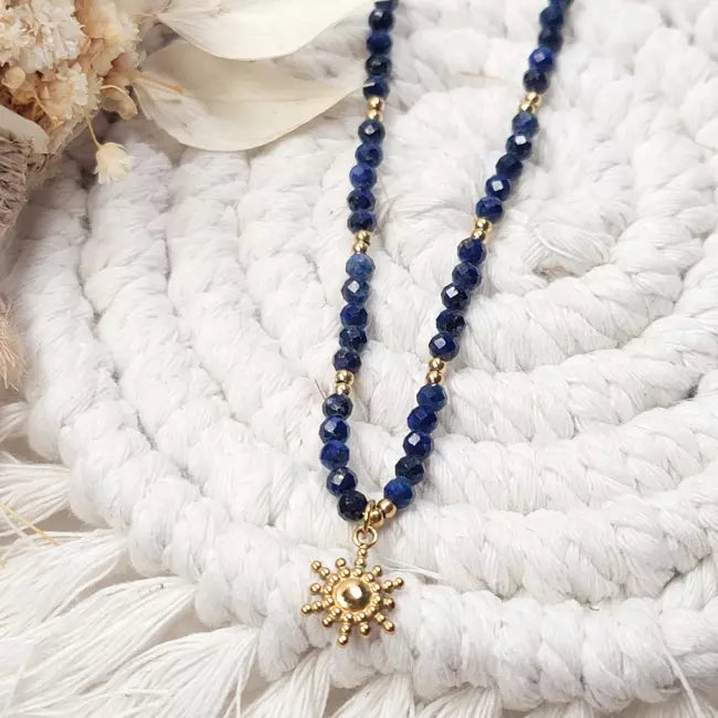 Collier soleil doré avec perles bleu marine porté, bijou élégant et bohème.