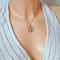Collier soleil doré femme porté, pendentif rond avec pierre blanche centrale, style chic.