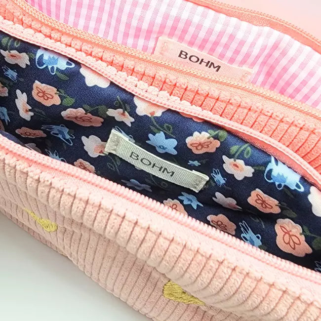 Intérieur de trousse en velours côtelé brodée de cœurs dorés, doublure fleurie et rayée